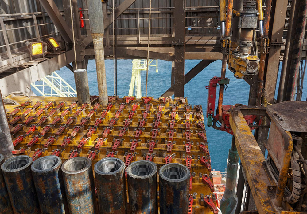 Man Using Measuring Tape in Factory Setting Man Using Measuring Tape in Factory Setting