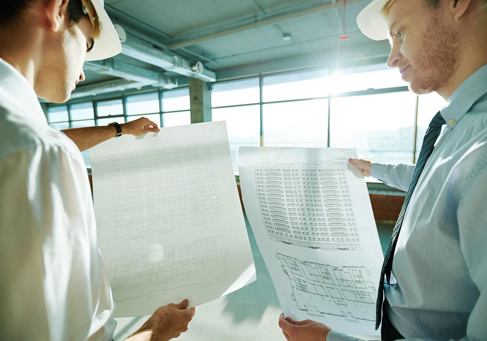 Man Using Measuring Tape in Factory Setting Man Using Measuring Tape in Factory Setting